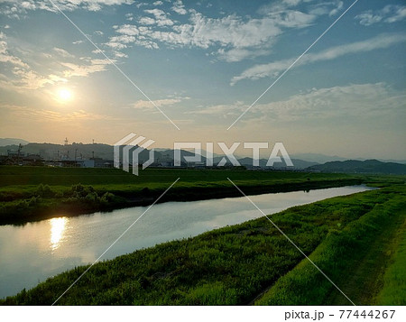 高知県四万十市を流れる四万十川の土手から夏の夕陽を眺める【6月】 高知県四万十市を流れる四万十川の土手から夏の夕陽を眺める【6月】 77444267