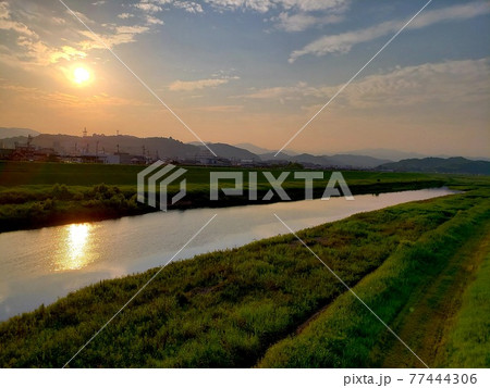 高知県四万十市(旧中村市)を流れる四万十川の土手から夏の夕陽を眺める【6月】 77444306