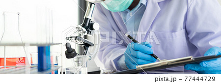 Young Asian scientist Working looking through a microscope doing research for analyzing a Experiments sample in a forensic laboratory. Young Asian scientist Working looking through a microscope doing research for analyzing a Experiments sample in a forensic laboratory. 77444729