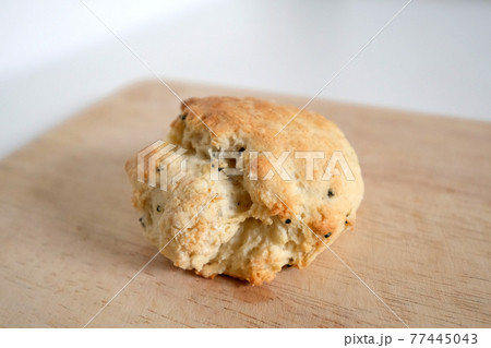 木のまな板に乗った焼き立ての紅茶スコーン 77445043
