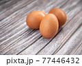 Close-up view of raw chicken eggs on wooden background. Eggs are often said to be the original superfood because of their many health benefits. 77446432