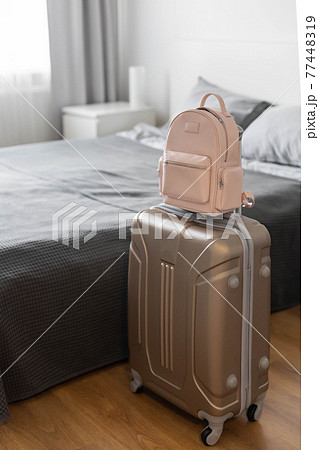 Modern suitcase full of things, handbag and straw hat. Baggage case packing getting ready to travel 77448319