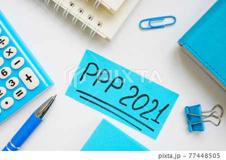 PPP loan 2021 handwritten words on a blue piece of paper. 77448505