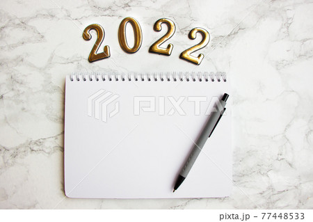 notebook with a blank sheet, a pen for writing plans for 2022 77448533