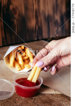 Top view of French fries. The concept of fast food, quick bites and restaurants for catering. Potatoes in carton and ketchup. Vertical photo 77448770