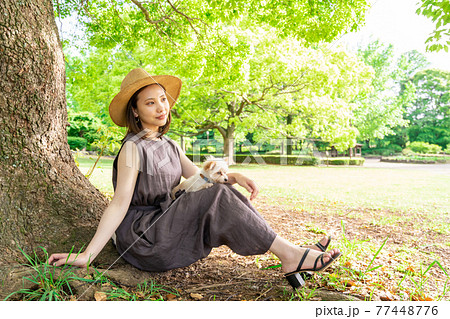 小型犬と散歩する若い女性　木陰でひと休み 77448776