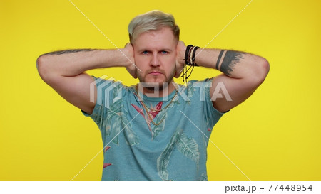 Frustrated irritated man covering ears, avoiding advice ignoring unpleasant noise loud voices Frustrated irritated man covering ears, avoiding advice ignoring unpleasant noise loud voices 77448954