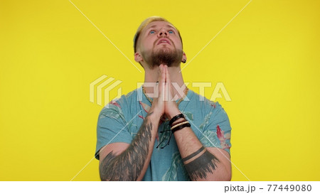 Trendy stylish man praying, looking upward and making wish, asking God for help, begging apology 77449080