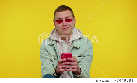 Teen boy using mobile phone typing new post on web sms message browsing addiction of social networks 77449291