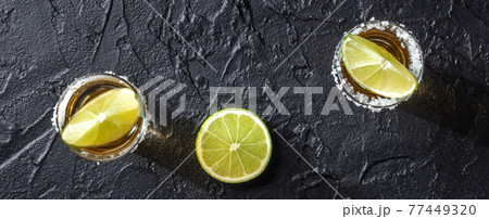 Tequila and lime panorama on a black background 77449320