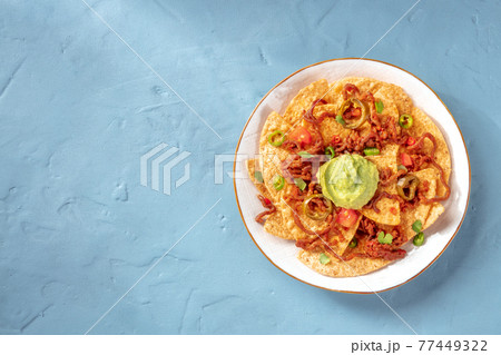 Nachos with ground beef, peppers, and guacamole, top shot with copyspace Nachos with ground beef, peppers, and guacamole, top shot with copyspace 77449322