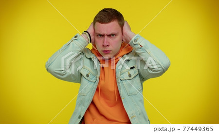 Frustrated irritated man covering ears, avoiding advice ignoring unpleasant noise loud voices Frustrated irritated man covering ears, avoiding advice ignoring unpleasant noise loud voices 77449365