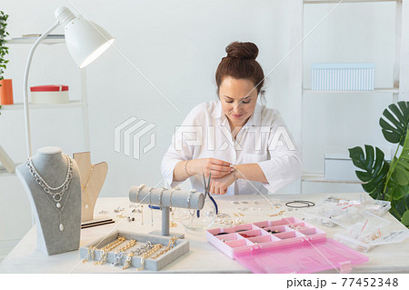 Professional accessories designer making handmade jewelry in studio workshop. Fashion, creativity and handmade concept. 77452348