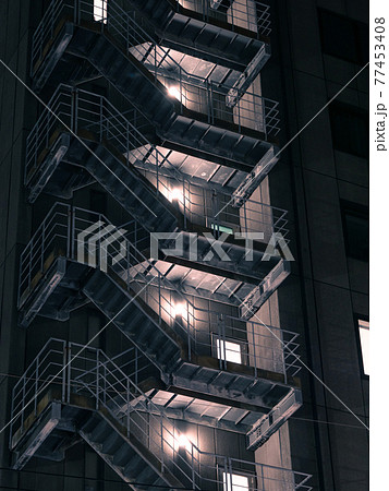 夜の古い高層ビルの非常階段 77453408