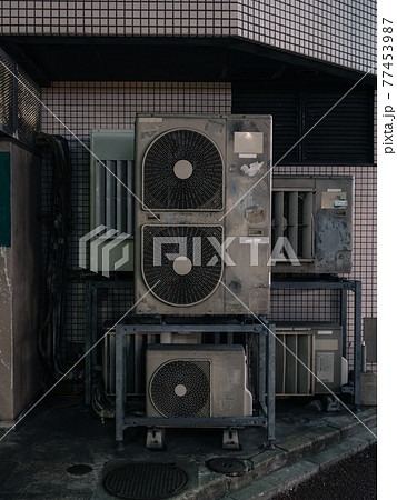 室外機が設置された夜の都会の裏路地 77453987