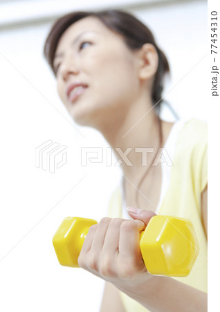 ダンベルでトレーニングする女性 77454310