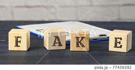 wooden cubes with the inscription fake on a blue background. The concept of information hygiene, propaganda 77456392