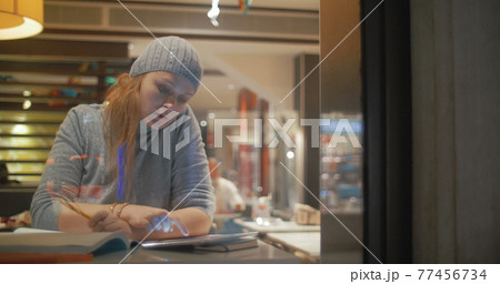 Woman Making Notes in Notebook 77456734