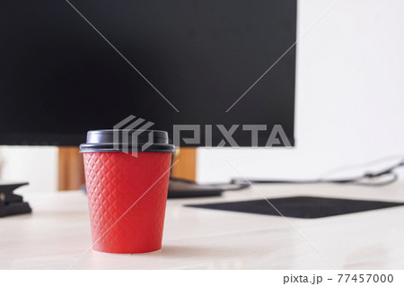 Red plastic coffee cup on the desktop 77457000