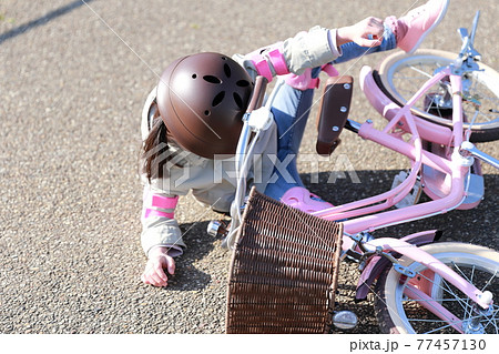 自転車の練習中に転んで怪我をする女の子 77457130