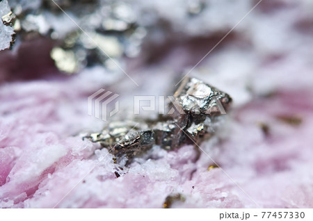 Pink crystals Rhodochrosite with particles of Pyrite. Natural  texture of mineral for background. Beautiful background and wallpaper. Macro. 77457330