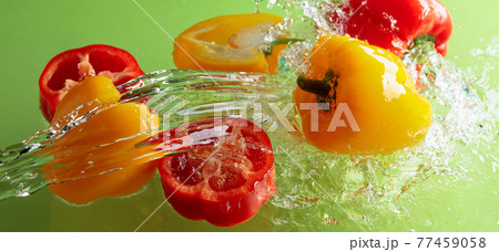 Red and yellow paprika in water splashes. 77459058