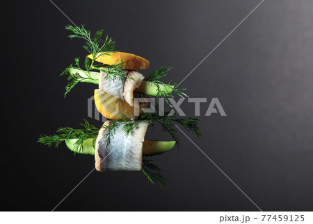 Herring fillet in oil with lemon, cucumber, and dill. 77459125