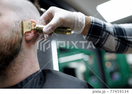 Obscured man client visiting haidresser in barber shop, midsection and close-up. Obscured man client visiting haidresser in barber shop, midsection and close-up. 77459134