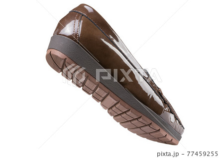 Brown women's patent leather low-soled shoes with a tread, as if walking, on a white background Brown women's patent leather low-soled shoes with a tread, as if walking, on a white background 77459255