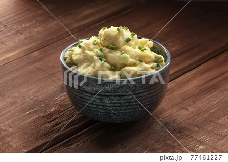 Pomme puree, a photo of a bowl of mashed potatoes with herbs on a dark rustic background Pomme puree, a photo of a bowl of mashed potatoes with herbs on a dark rustic background 77461227