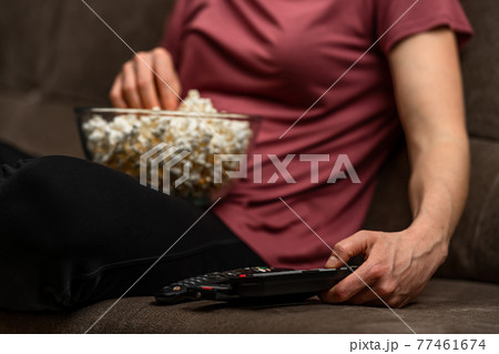 remote control and popcorn when watching a movie and broadcasting 77461674