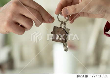 Woman passes the keys to the new house in the hands of man against the background of repairs in the house. The concept of the sale of real estate Woman passes the keys to the new house in the hands of man against the background of repairs in the house. The concept of the sale of real estate 77461906