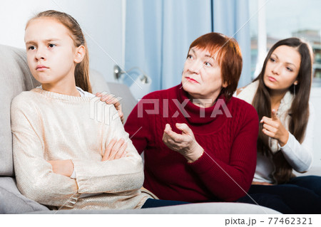Frustrated girl while mother and grandmother berating her Frustrated girl while mother and grandmother berating her 77462321