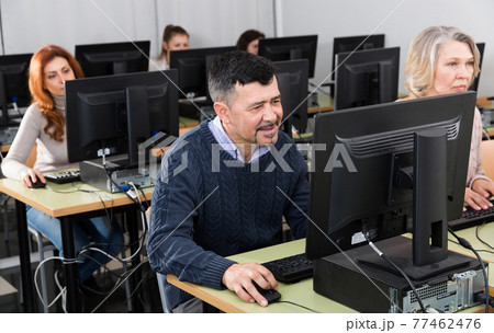 Middle aged man taking computer lessons Middle aged man taking computer lessons 77462476