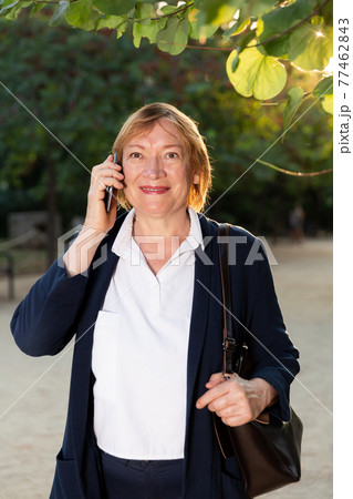 Elderly woman talking on smartphone 77462843