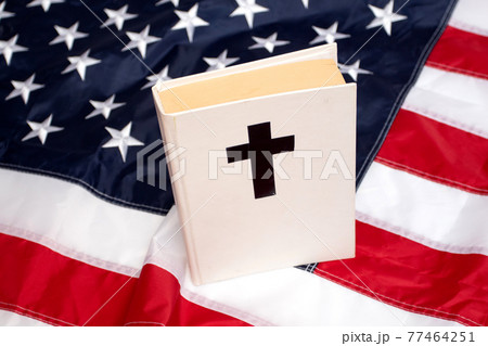 Holy Bible book with a cross on American flag 77464251
