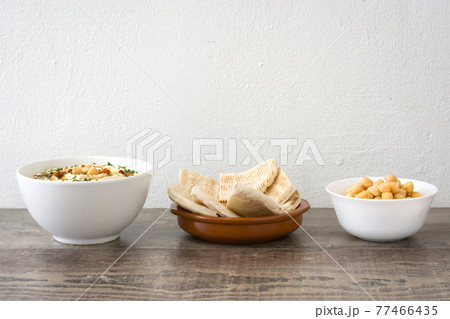 Hummus on a rustic wooden table Hummus on a rustic wooden table 77466435