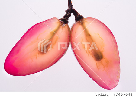 Two Translucent slices of ripe red grapes macro. Isolated on white background. Top view. 77467643