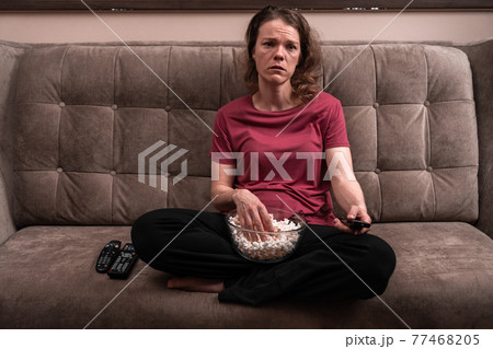 emotions when watching TV at home with popcorn. sadness and compassion emotions when watching TV at home with popcorn. sadness and compassion 77468205