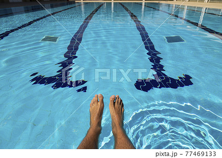 The feet of a young man in a swimming pool in summer, Spain. The feet of a young man in a swimming pool in summer, Spain. 77469133
