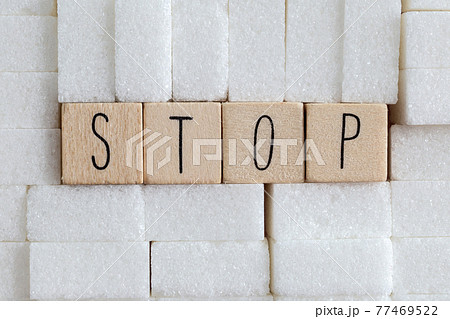 Pile or wall of sugar cubes and stop word in block letters as advise on addiction calories excess and sweet unhealthy food abuse causing health problem and overweight background Pile or wall of sugar cubes and stop word in block letters as advise on addiction calories excess and sweet unhealthy food abuse causing health problem and overweight background 77469522