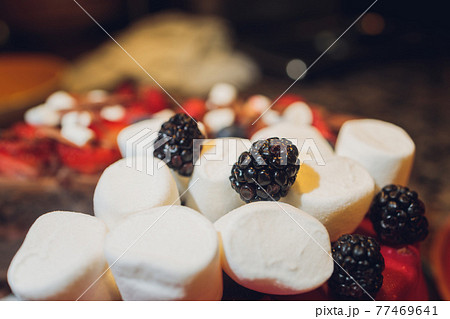Decorated Biscuit Cake With Berries, Chocolate, Marshmallow On Grey Background. Close Up. Decorated Biscuit Cake With Berries, Chocolate, Marshmallow On Grey Background. Close Up. 77469641