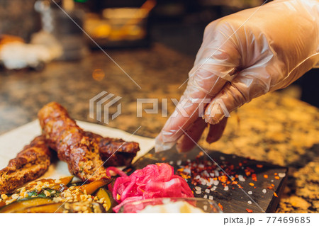 The Chef prepares meat on the barbecue. The Chef prepares meat on the barbecue. 77469685