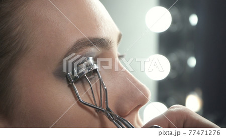 Photo of master using eyelash curler on eyes 77471276