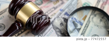 On table is magnifying glass calculator and a judge's hammer On table is magnifying glass calculator and a judge's hammer 77472557