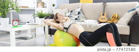 Woman lies on fitball and does abdominal exercises Woman lies on fitball and does abdominal exercises 77472580
