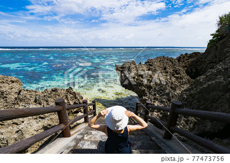 沖縄の浜辺で白い帽子の女性 宮古諸島 伊良部島の海へ続く階段のシンビジ 沖縄の浜辺で白い帽子の女性 宮古諸島 伊良部島の海へ続く階段のシンビジ 77473756