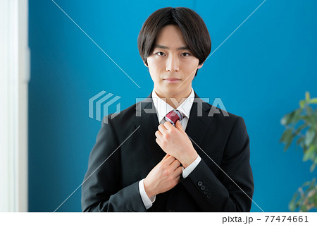 ネクタイを締める若いビジネスマン ネクタイを締める若いビジネスマン 77474661