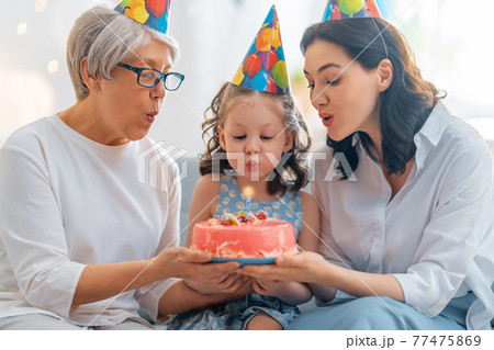 Grandmother, mother and daughter are celebrating birthday. Grandmother, mother and daughter are celebrating birthday. 77475869