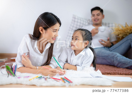 Young family drawing together with colorful pencils at home 77477386